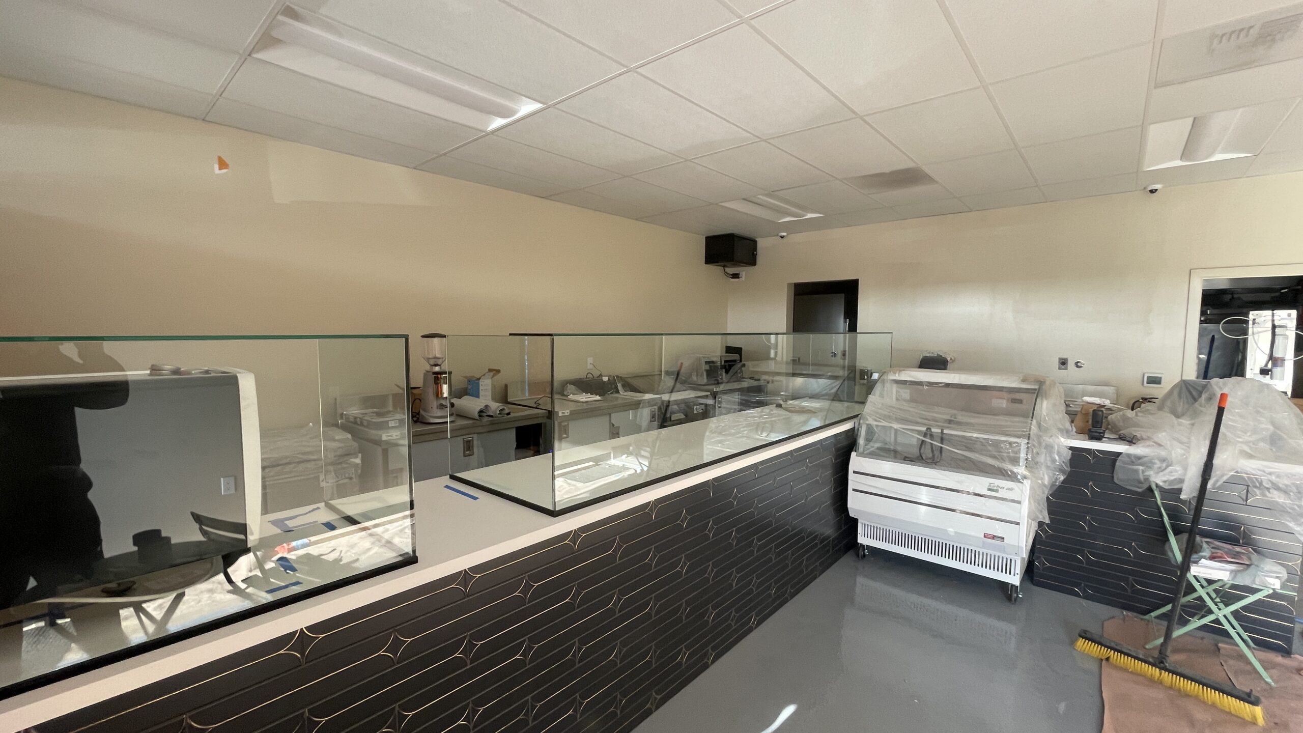 Custom glass sneeze guard installed in El Segundo using CRL UV Glue for seamless joints and durability