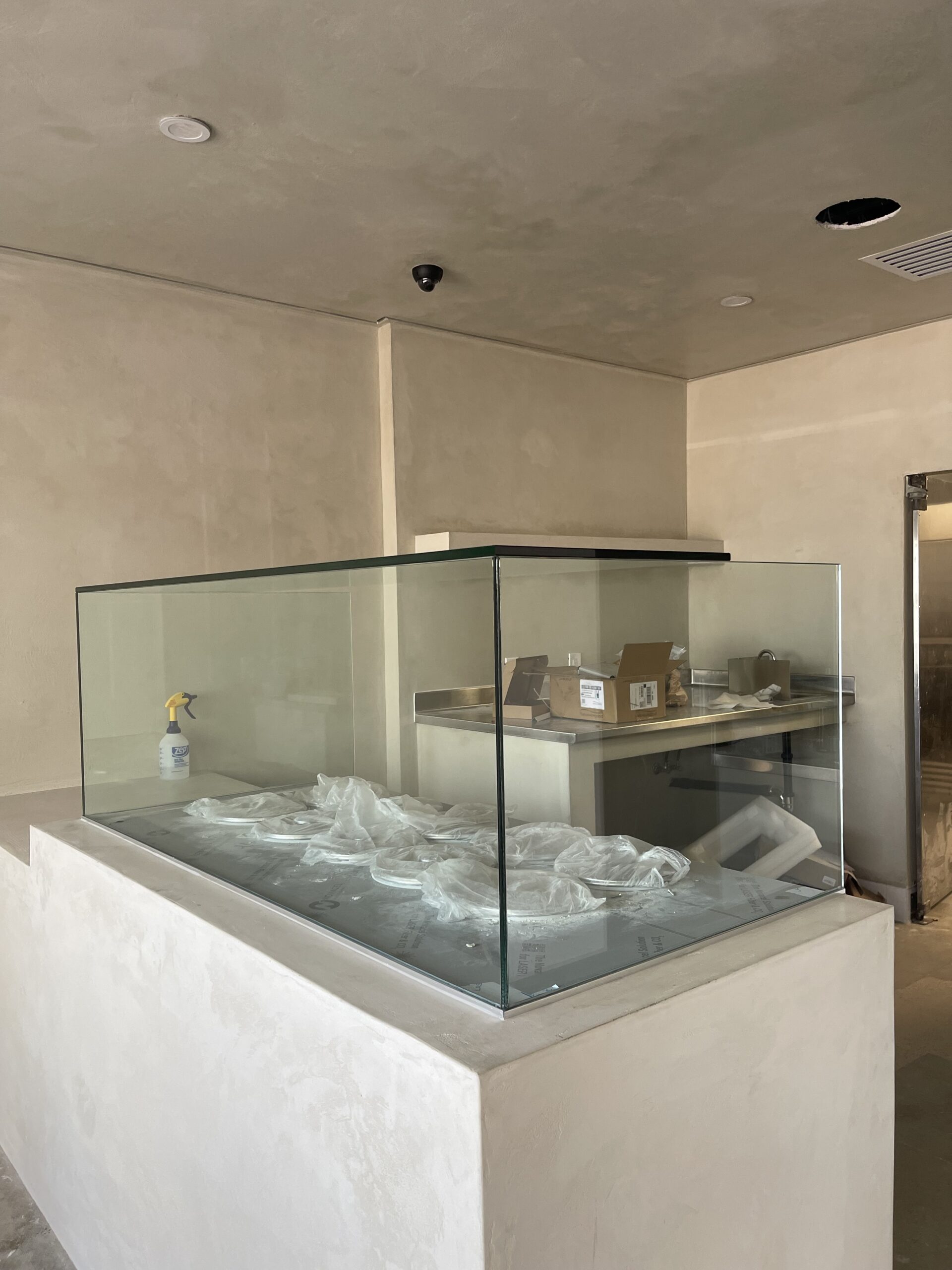 Custom glass sneeze guard installation with tempered glass panels for food service counter in Orange County