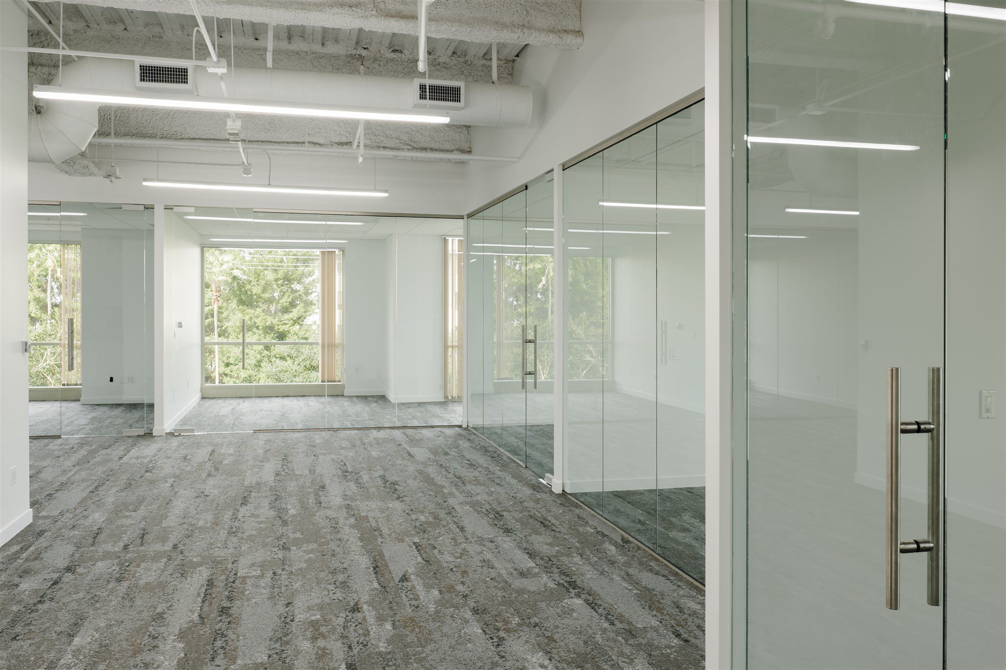 Glass partition wall with frameless glass doors in Irvine office interior